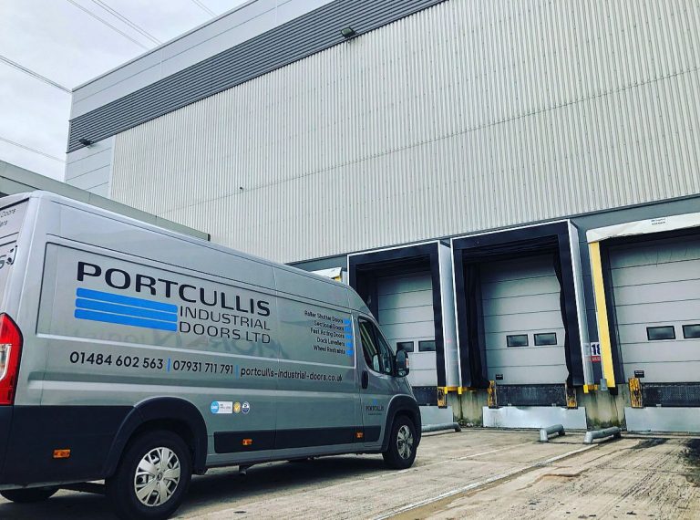Portcullis Industrial Doors Van at warehouse entrance.